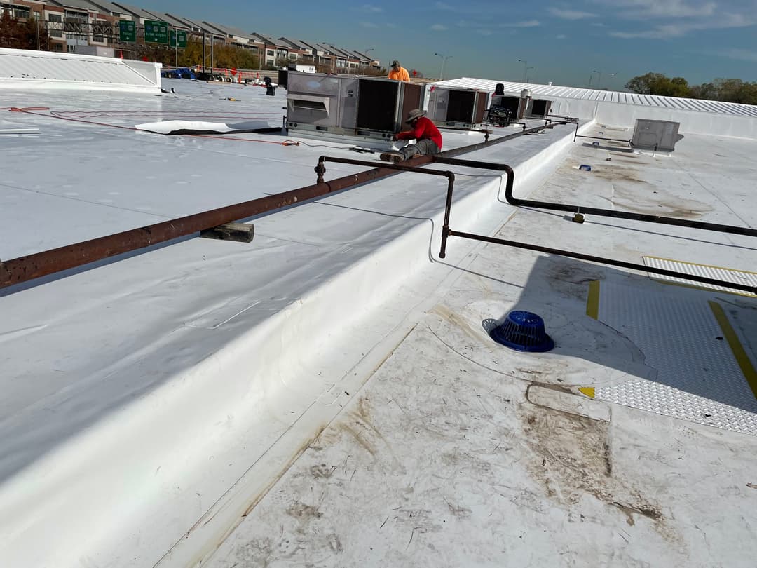Workers on a commercial rooftop installing HVAC units and maintenance equipment.