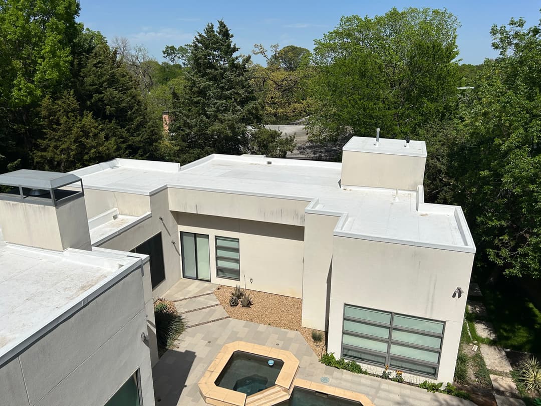 Modern residential home with landscaped yard and minimalist design amidst lush greenery.