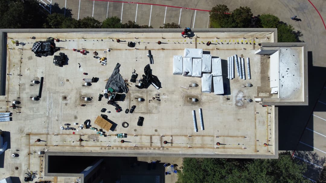 Aerial view of a rooftop under construction with equipment and materials spread across.