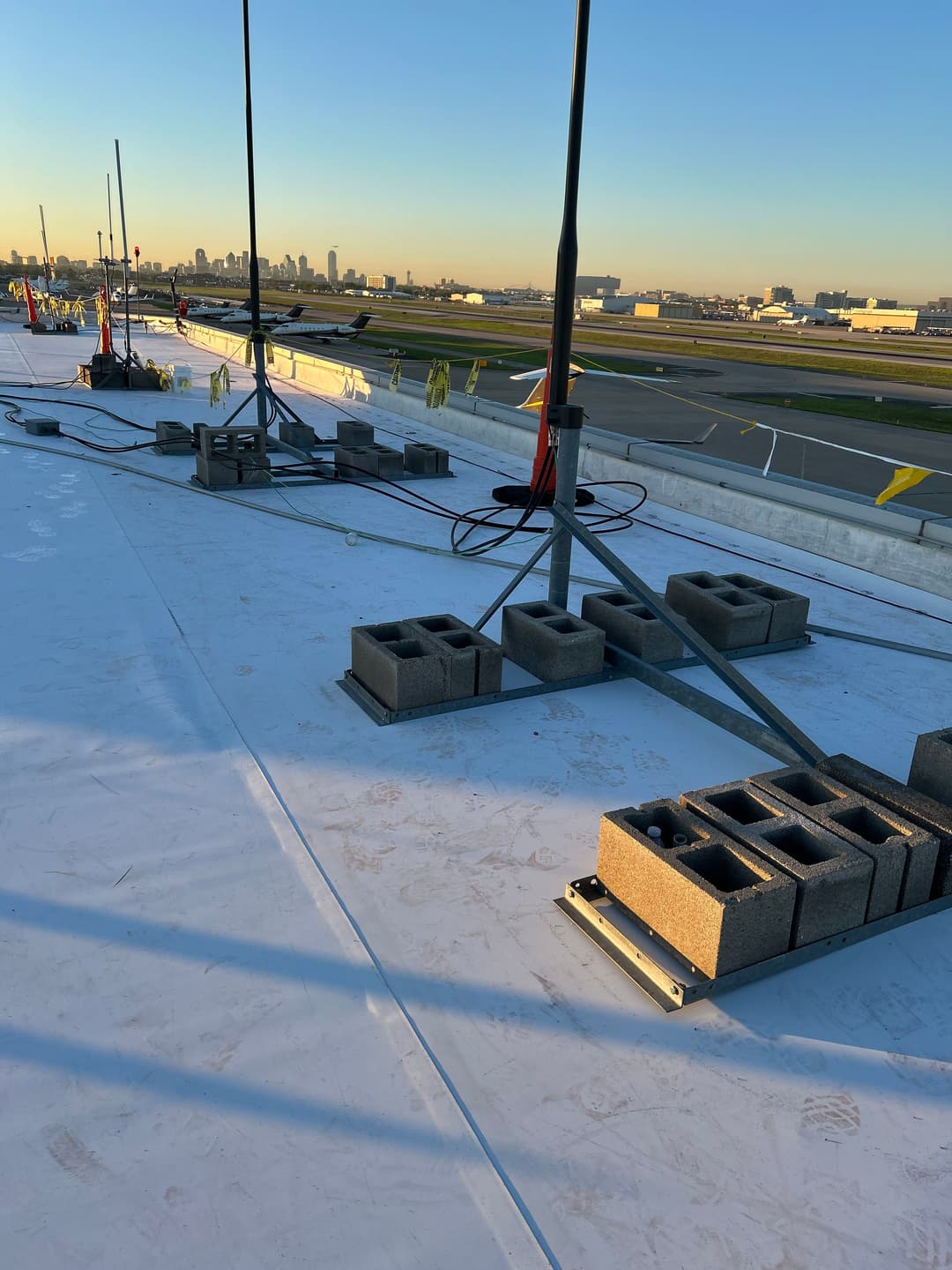 Rooftop view of construction site with concrete blocks and distant city skyline.
