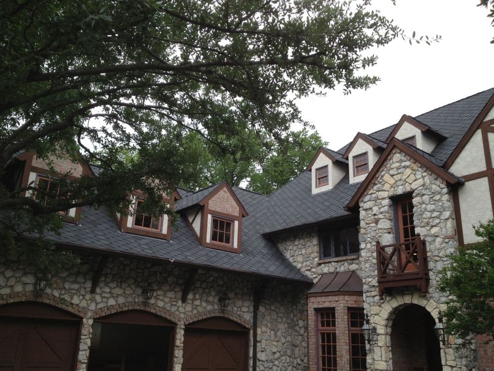 Elegant stone house with multiple gabled roofs and detailed architectural features.